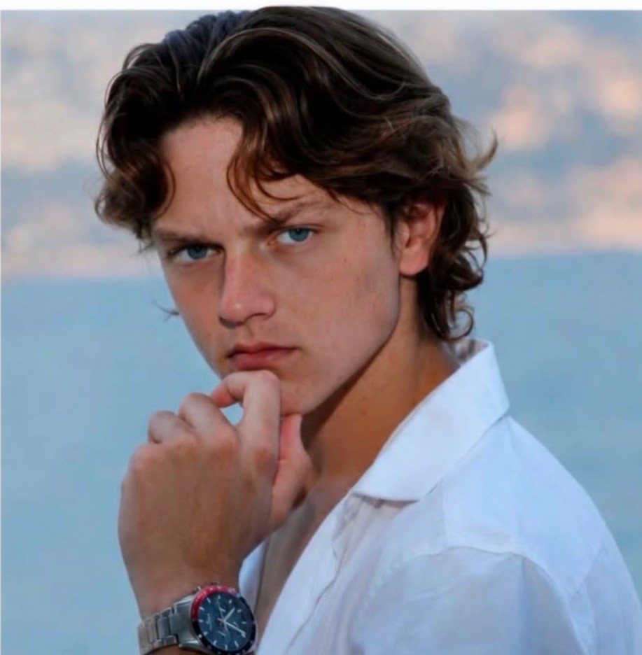 Leo Cole, male model, portrait in a white shirt against a coastal backdrop